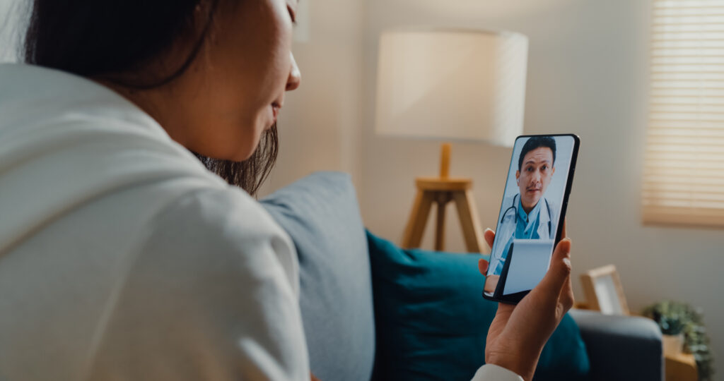Woman attending a telehealth appointment with a doctor on a smartphone via seraya health