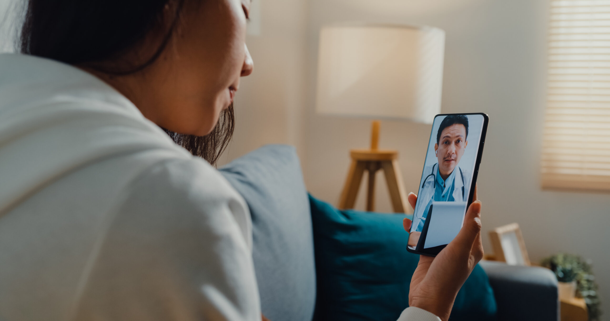 Woman attending a telehealth appointment with a doctor on a smartphone via seraya health