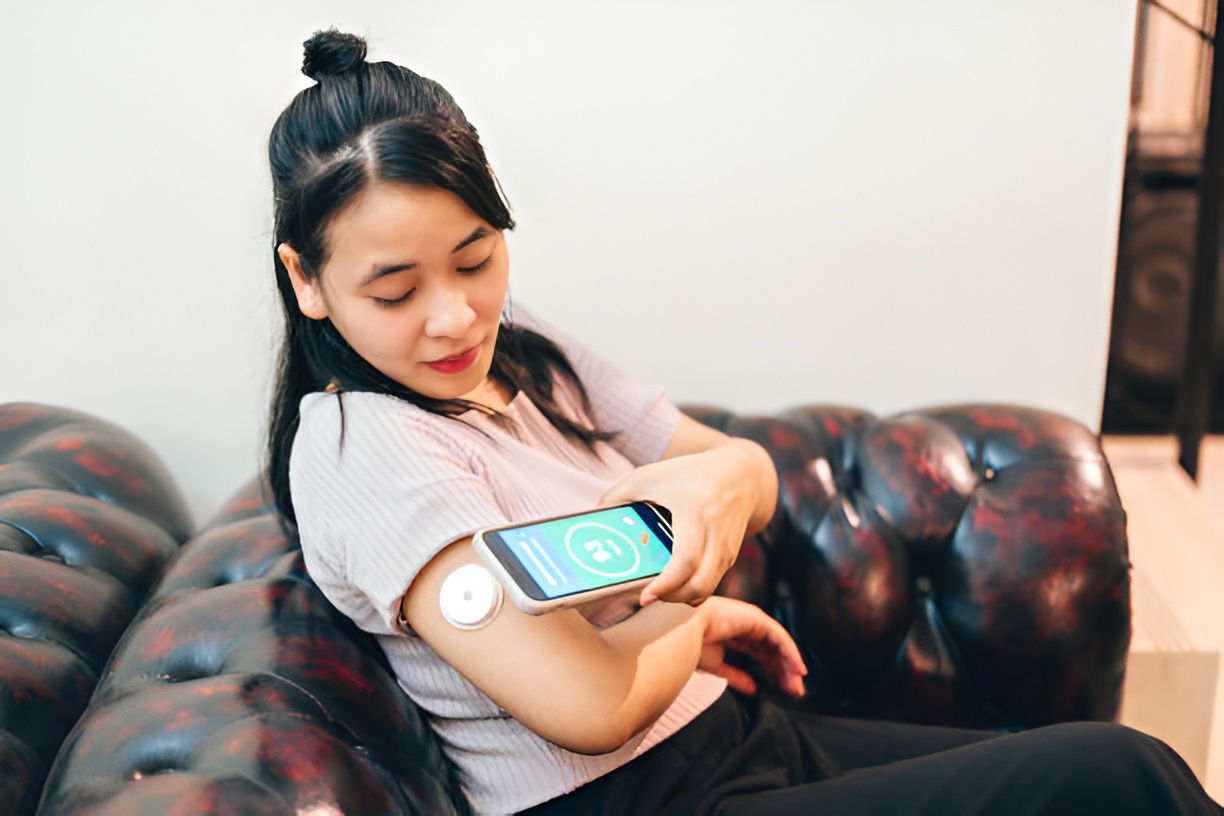 Woman using smartphone to scan CGM on her arm