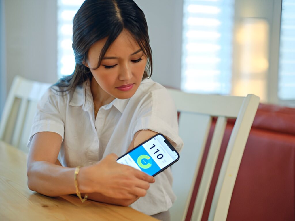 Woman monitoring sugar levels with CGM on smartphone