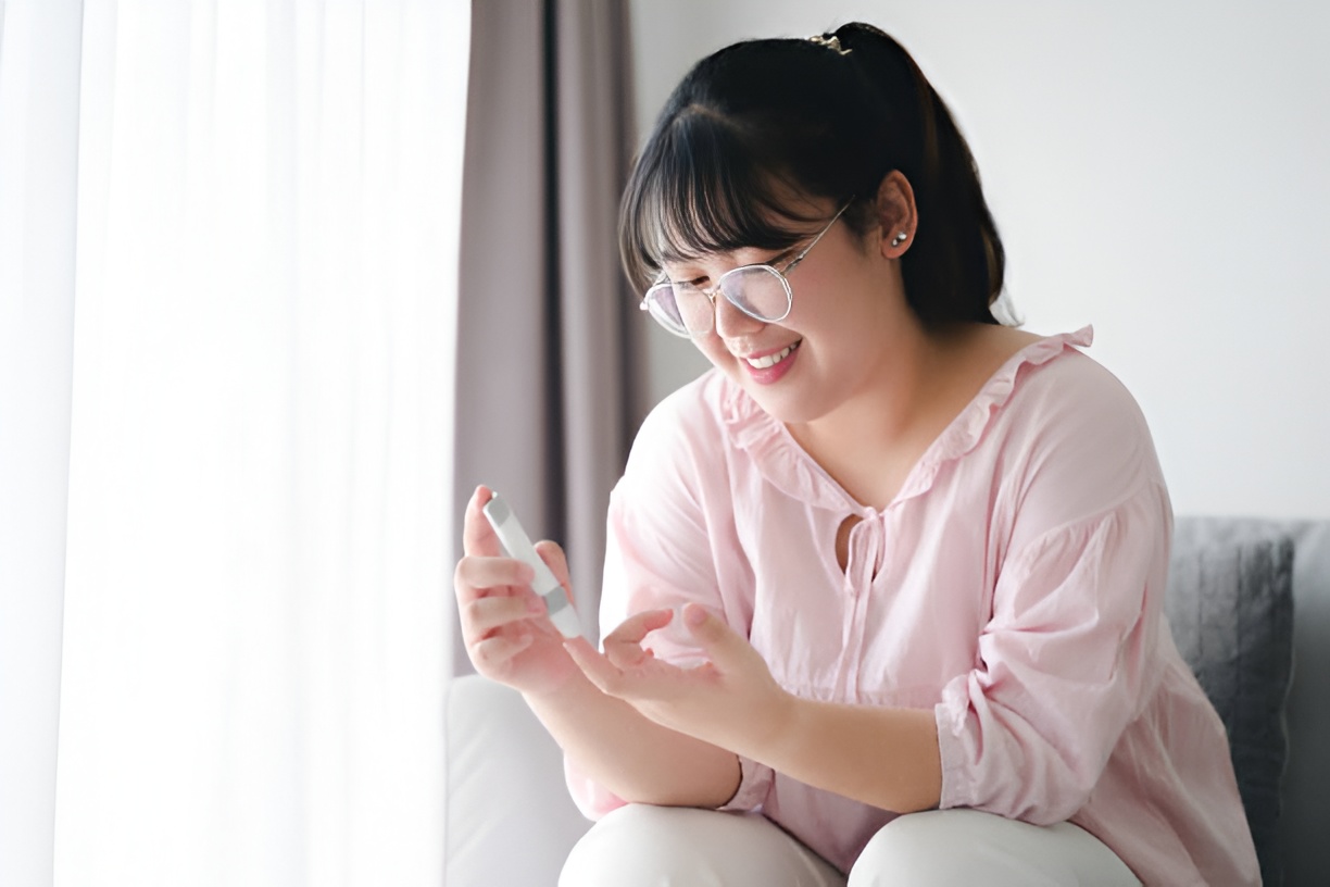 Woman performing a finger-prick glucose random blood test at home
