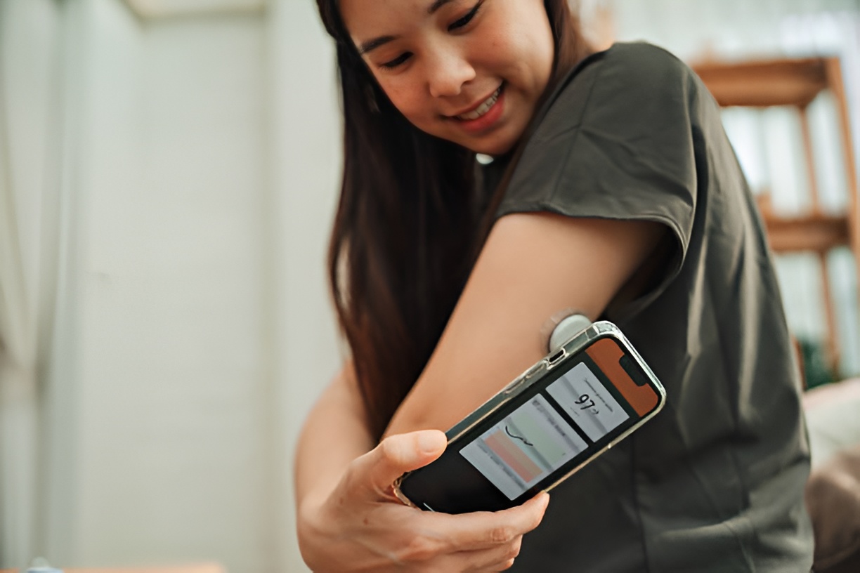 Woman with Type 1 Diabetes monitoring blood sugar with a CGM device
