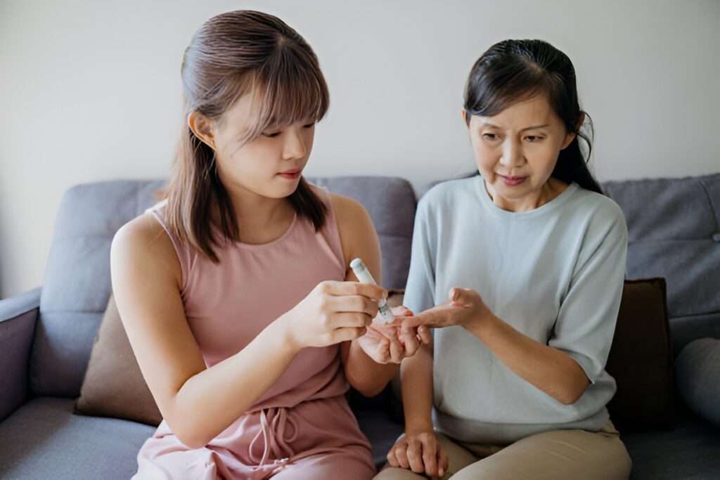 Young woman doing a blood sugar glucose test on an older woman's finger at home
